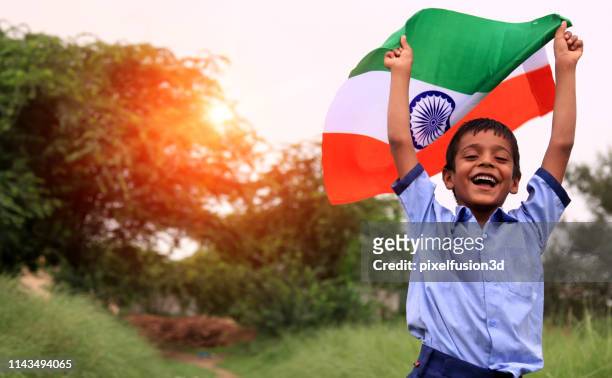 cheerful elementary age child portrait with indian national flag - patriotism india stock pictures, royalty-free photos & images