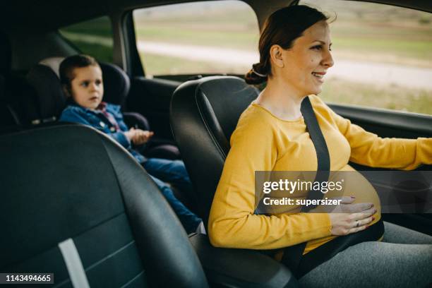 mother and son driving in a car - pregnant woman car stock pictures, royalty-free photos & images