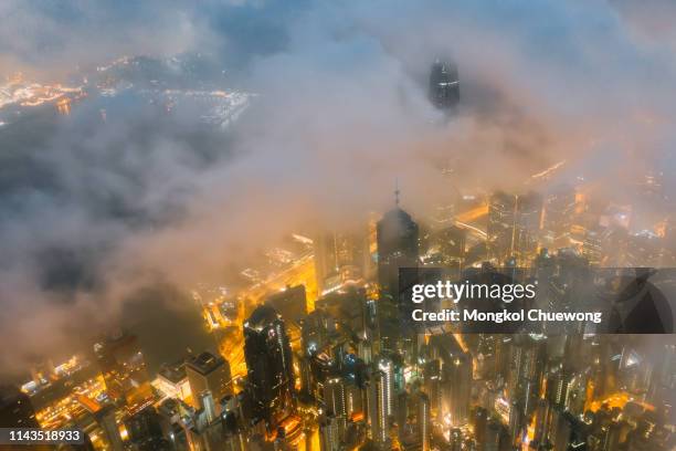 aerial view of hong kong city skyline at night over the mist - hong kong skyline drone stock pictures, royalty-free photos & images