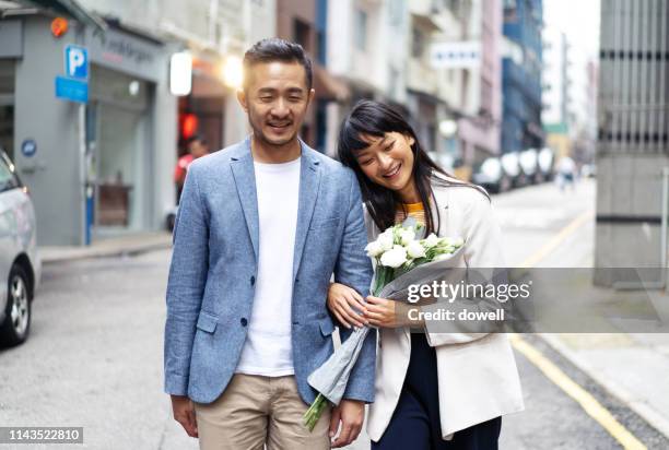 chinese couple walking at street in hong kong - asian young couple stock pictures, royalty-free photos & images