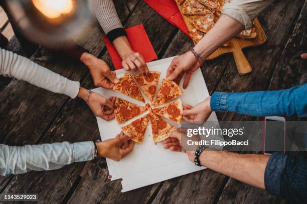 friends taking a slice of pizza from the pizza box - pizza slice stock pictures, royalty-free photos & images