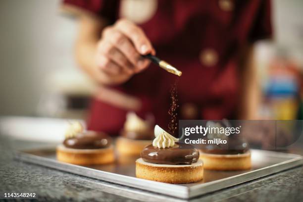 vrouw maken cakes in cake vervaardiging - chocolate powder stockfoto's en -beelden