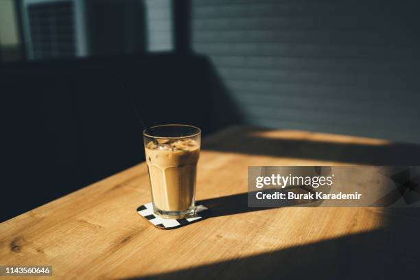 dramatic shot of ice coffee at sunset with shadow - coffee on table stock pictures, royalty-free photos & images