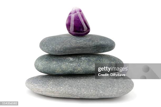 púrpura, gema amethyst en ello piedras negras - reiki fotografías e imágenes de stock
