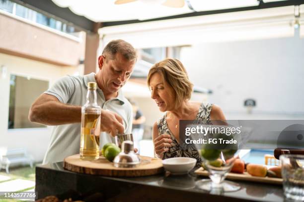 man undervisar kvinnan hur man gör en caipirinha - summer cocktails garden party drinks bildbanksfoton och bilder