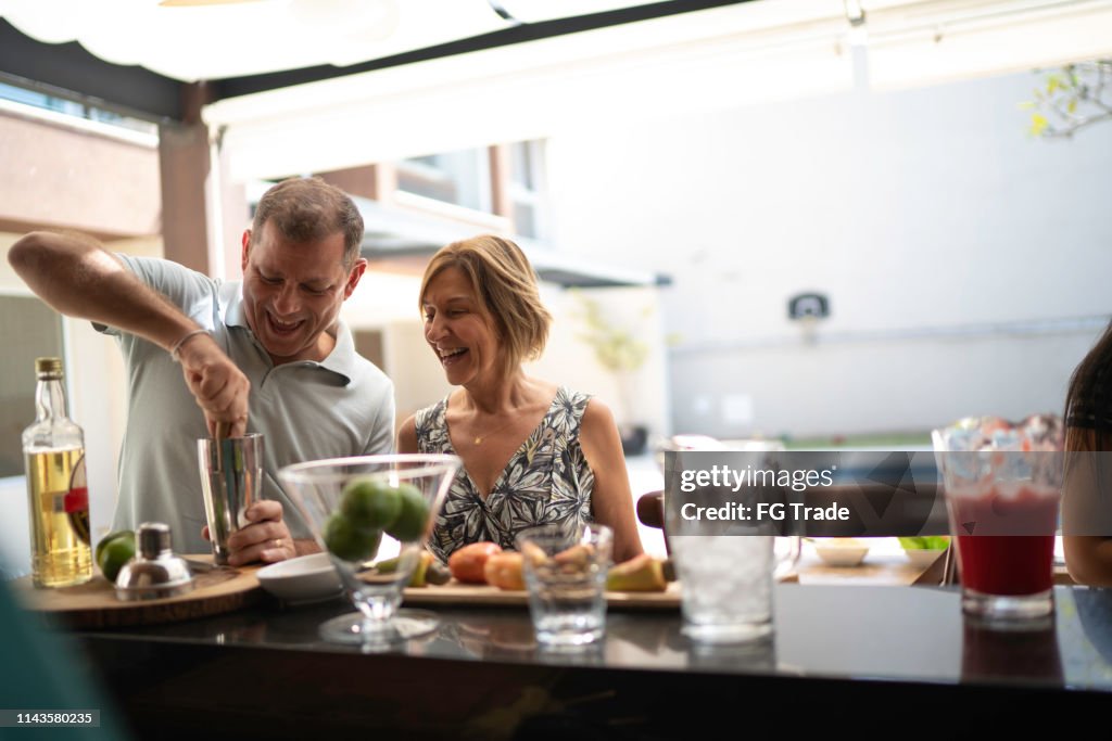 Man teaching woman how to make a caipirinha