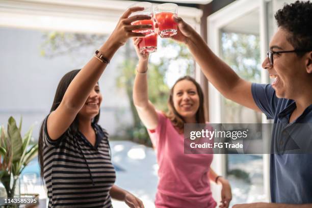 vrienden toasten met caipirinha - summer cocktails garden party drinks stockfoto's en -beelden