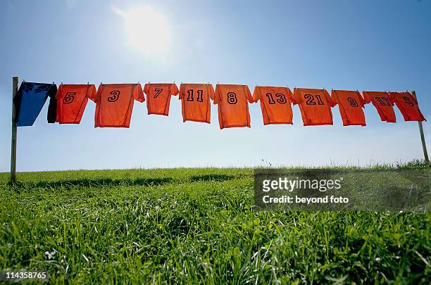 football dresses hanging on clothesline - trikot stock-fotos und bilder