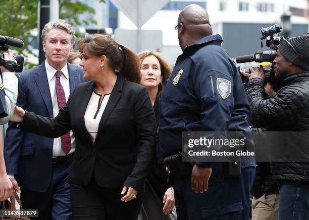 Actress Felicity Huffman, center, is escorted by a police office as she enters the John Joseph Moakley United States Courthouse with her brother...