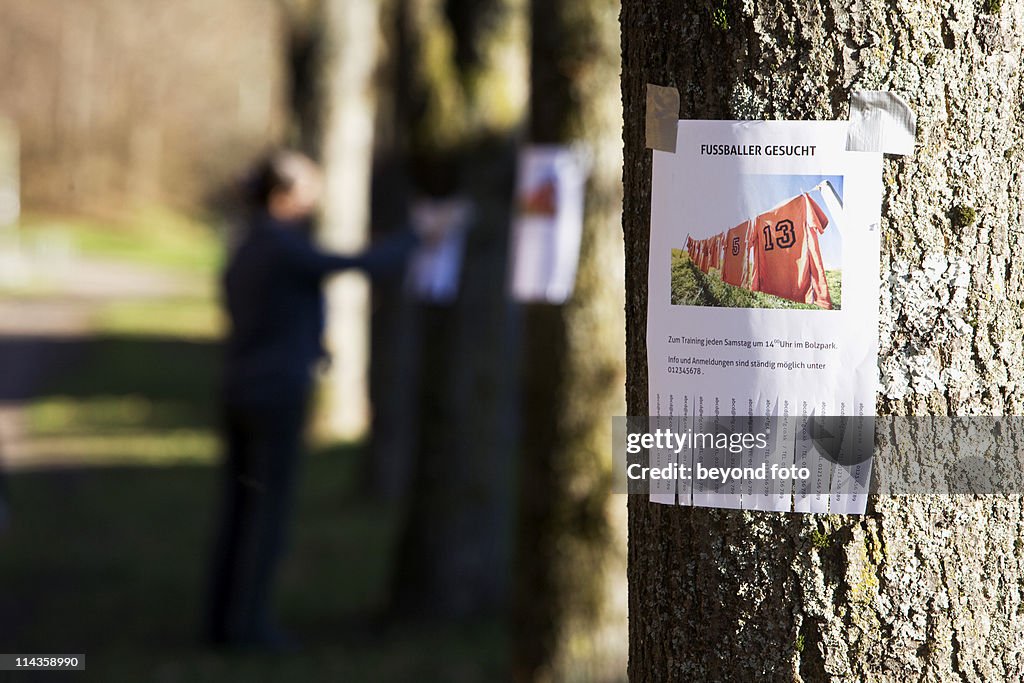 Note with ad searching for football players sticking on tree