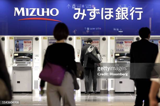 Customer uses an automated teller machine at a branch of Mizuho Bank Ltd., a unit of Mizuho Financial Group Inc. , in Tokyo, Japan, on Friday, May...