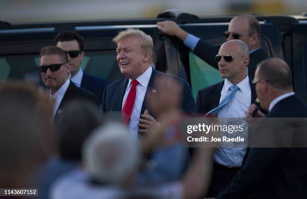 President Donald Trump greets supporters after arriving on Air Force One at the Palm Beach International Airport to spend Easter weekend at his...