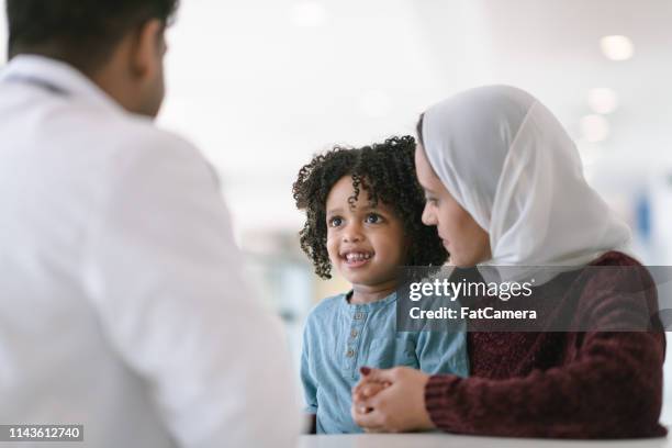 mother and son at medical appointment - clinic canada diversity imagens e fotografias de stock