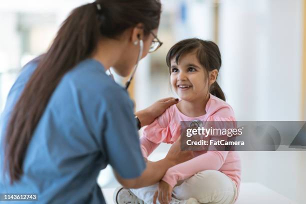 female doctor checks girl's heartbeat - nurse listening to patient stock pictures, royalty-free photos & images