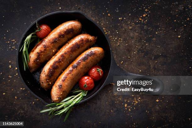 salchichas en una sartén - salchicha fotografías e imágenes de stock