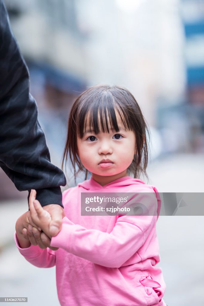 Asian Family Of Three Walking On Hong Kong Street High-Res Stock Photo
