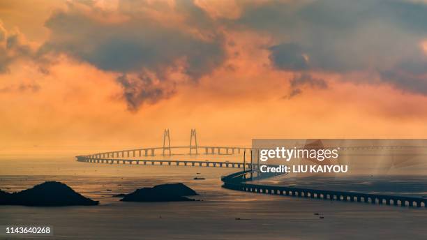 huge bridge with beautiful sunset hong kong-zhuhai-macau bridge - macao stock-fotos und bilder