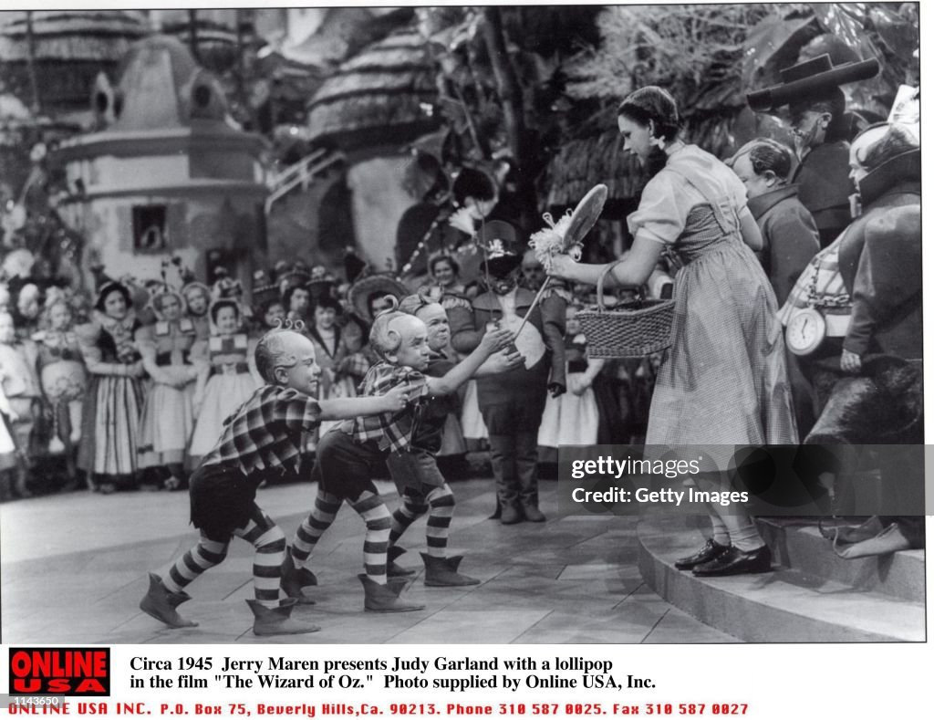 Jerry Maren presents Judy Garland with a lollipop in the film "The Wizard of Oz."