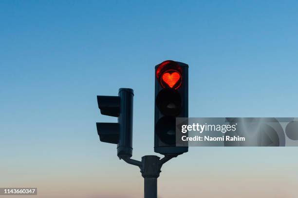 heart-shaped red stop traffic light in akureyri, iceland - rood stoplicht stoplicht stockfoto's en -beelden