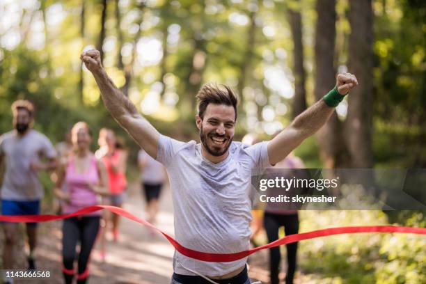 coureur heureux gagnant de course de marathon et ligne d’arrivée de croisement avec des bras levés. - finish line photos et images de collection