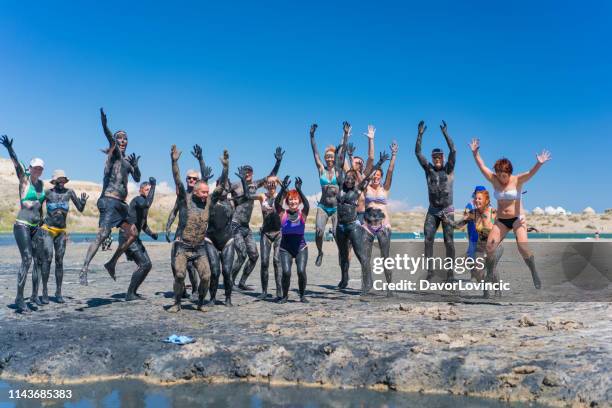 tourists at issyk-kul salty lake smearing mud over their bodies,  kyrgyzstan - lake issyk kul stock pictures, royalty-free photos & images