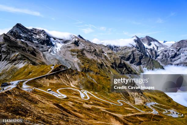 mountain road and sea of clouds mountains against sky in austrian alps - grossglockner fotografías e imágenes de stock