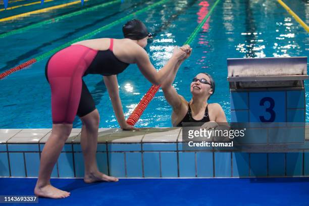 female swimmers congratulating for victory - competition group stock pictures, royalty-free photos & images