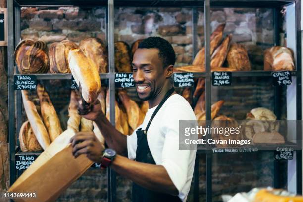 african man working in bread pastry. - baker man stock-fotos und bilder