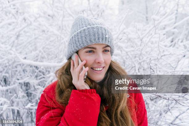 close-up laughs woman in red down jacket speaks by phone - look down stock-fotos und bilder