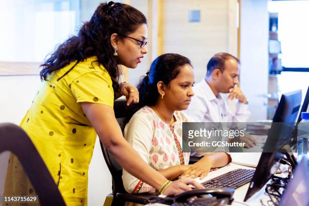 mujer gerente de la oficina de entrenamiento nuevo personal sobre su sistema crm - india fotografías e imágenes de stock