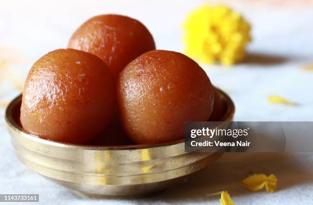 gulab jamun/indian dessert in a brass bowl against white background - gulab jamun stock pictures, royalty-free photos & images