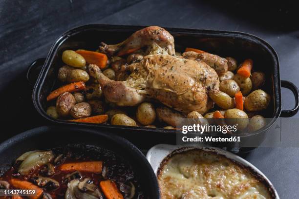 chicken a la coq au vin with onion gratin, red vine sauce and baked potato - coq au vin stock-fotos und bilder
