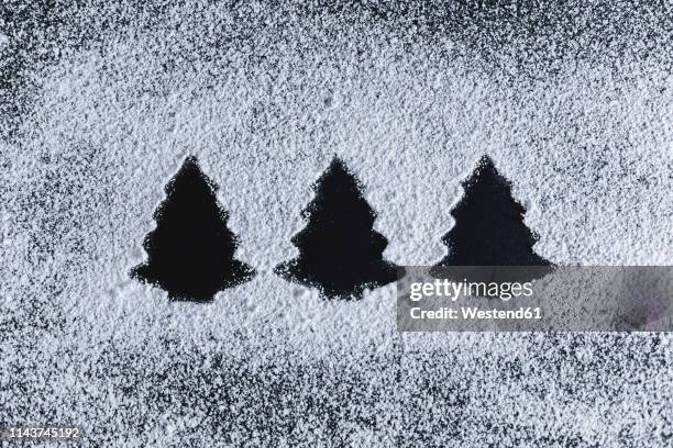 icing sugar on black background, fir trees - zucchero a velo foto e immagini stock