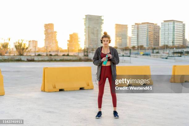 sportive young woman with headphones during workout - bollards foto e immagini stock