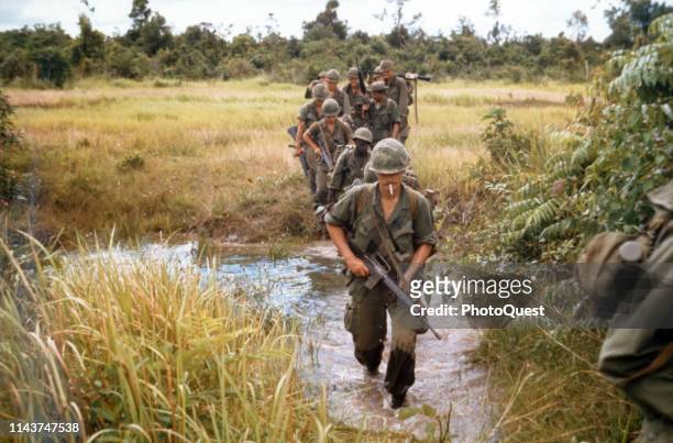 Members of Company B, 1st Battalion, 27th Infantry Regiment , 25th Infantry Division, cross a stream during search and clear operation near Fire...