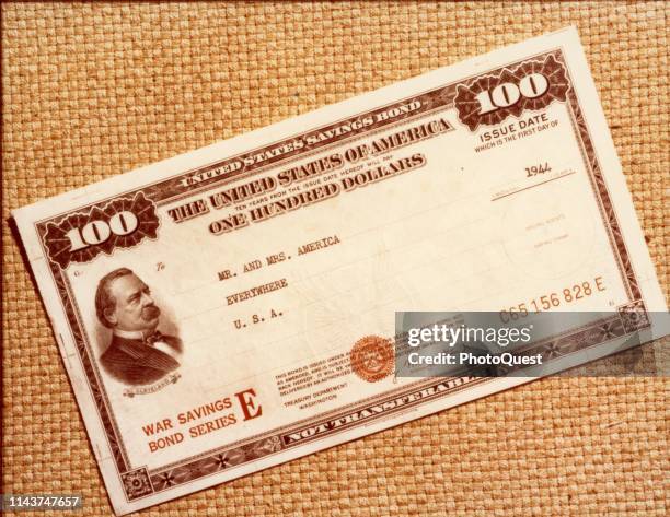 View of a one hundred dollar, Series E, United States War Savings Bond made out to 'Mr and Mrs America, Everywhere, USA,' 1945.