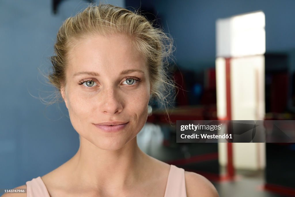 Portrait of confident young blond woman in a gym