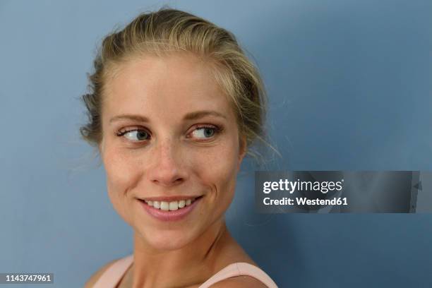 portrait of smiling young blond woman looking sideways - at a glance foto e immagini stock