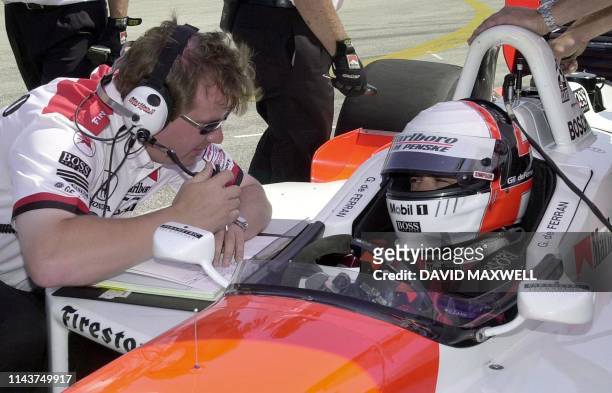 Brazilian driver Gil de Ferran talks with a member of his crew while preparing to take the track during qualifying for the Marconi Grand Prix of...