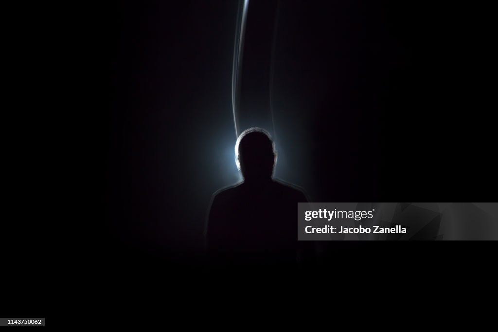 Silhouette of man in dark tunnel