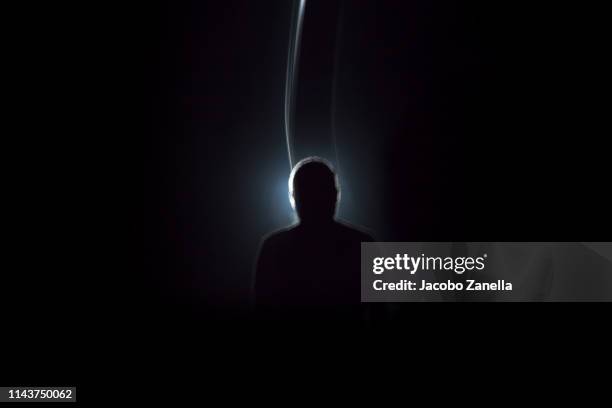 silhouette of man in dark tunnel - suit photos et images de collection