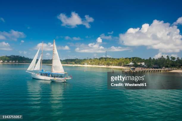 fiji, mamanuca islands, sailing boat anchoring on mana island - western division fiji stock pictures, royalty-free photos & images