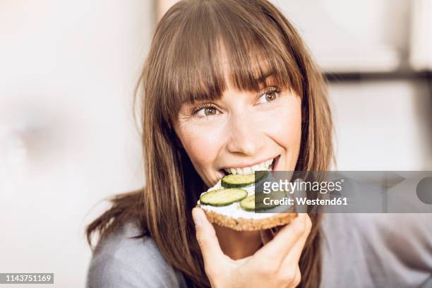 mature woman eating healthy cucumber bread - eating bread stockfoto's en -beelden