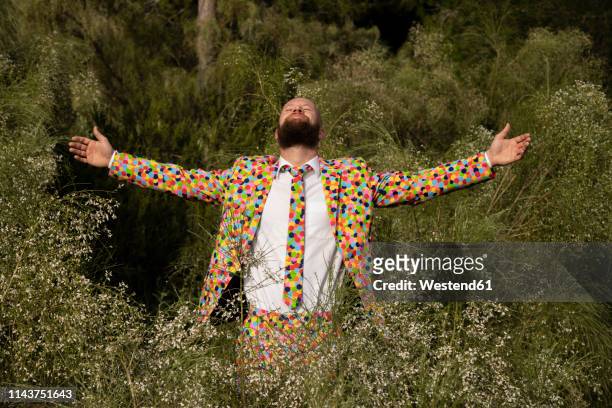 bearded man wearing suit with colourful polka-dots enjoying nature - spinner stock-fotos und bilder