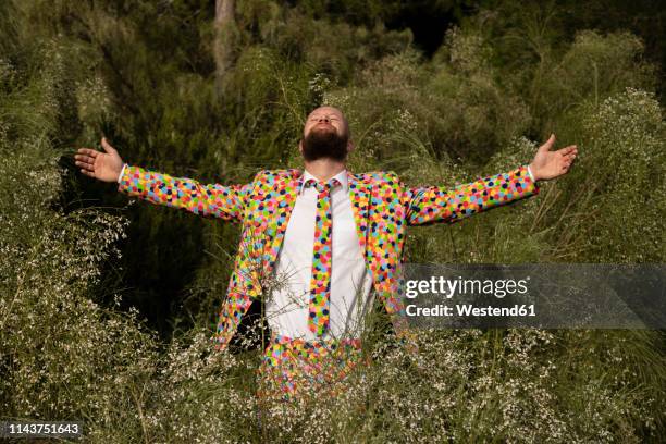 bearded man wearing suit with colourful polka-dots enjoying nature - excentriek stockfoto's en -beelden