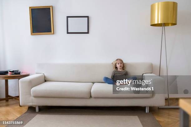 bored girl sitting on the couch at home - floor lamp stock pictures, royalty-free photos & images