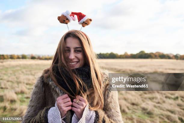 portrait of happy young woman wearing christmassy headdress in the countryside - headdress stock-fotos und bilder