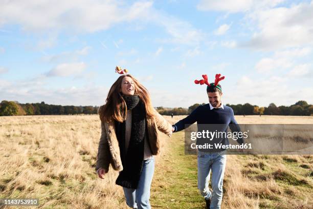 happy carefree couple wearing christmassy headdress in the countryside - country christmas 個照片及圖片檔