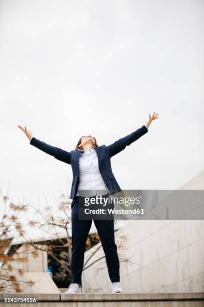 happy businesswoman spreading her arms in the city - arms open stock pictures, royalty-free photos & images