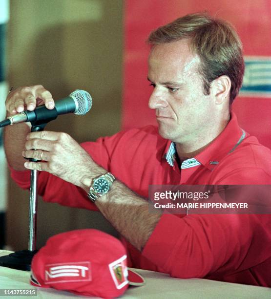 Brazilian F1 driver Rubens Barrichello gives a press conference. El piloto brasileno de F.1, Rubens Barrichello, arregla la altura de un microfono...
